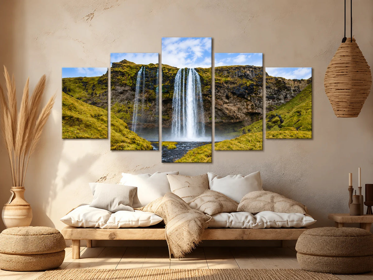 The same waterfall scene displayed across five staggered canvas panels above a cushioned wooden bench.